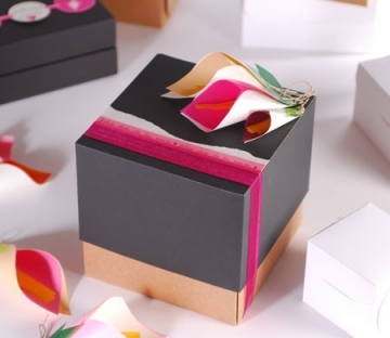 Boîte cadeau en forme de cube avec ruban et fleurs