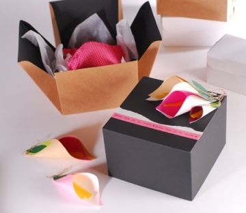 Boîte cadeau en forme de cube avec ruban et fleurs